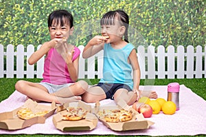Asian Chinese little sisters eating pizza