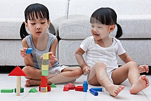 Asian Chinese little sisters playing blocks on the floor