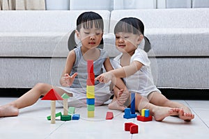 Asian Chinese little sisters playing blocks on the floor