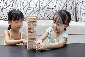 Asian Chinese little sisters playing wooden stacks