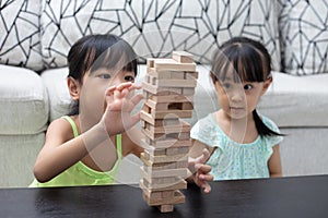 Asian Chinese little sisters playing wooden stacks
