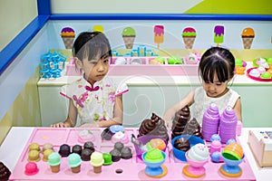 Asian Chinese little sisters role-playing at ice cream store