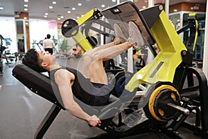 Asian chinese man in gym ï¼ŒFitness sport man Training of leg strength in the gym