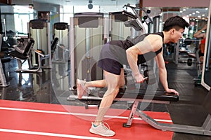Asian chinese man in gym ï¼ŒFitness young man in the gym doing exercises with dumbbells