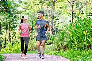 Asian Chinese man and woman jogging in city park