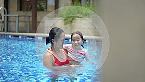 Asian Chinese mother and daughter bonding at the pool