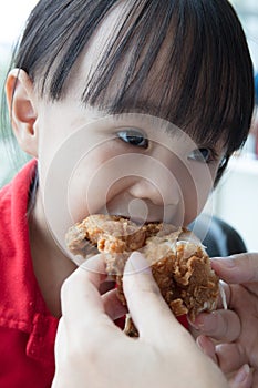 Asian Chinese mother and daughter eating fried chicken