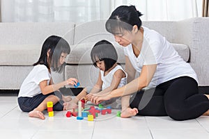 Asian Chinese mother and daughter playing blocks on the floor