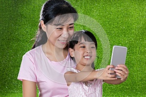 Asian Chinese mother and daughter playing with smartphone