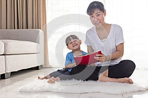 Asian Chinese mother and daughter reading on the floor