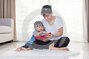 Asian Chinese mother and daughter reading on the floor