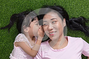 Asian Chinese mother and daughter whispering and gossiping