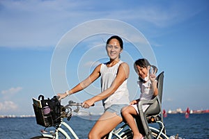 Asian Chinese Mother and daugther cycling outdoors with COVID mask photo