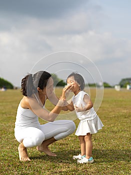Asian chinese mother helps child cleans her nose