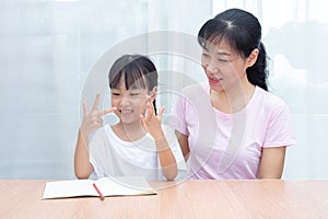 Asian Chinese mother teaching daughter mathematics by counting f