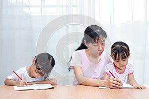 Asian Chinese mother teaching daughters doing homework