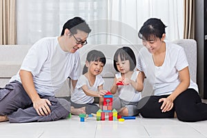 Asian Chinese parents and daughters playing blocks on the floor