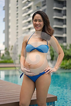 Asian Chinese Pregnant Woman Mother posing by the swimming pool