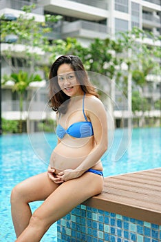 Asian Chinese Pregnant Woman Mother posing by the swimming pool