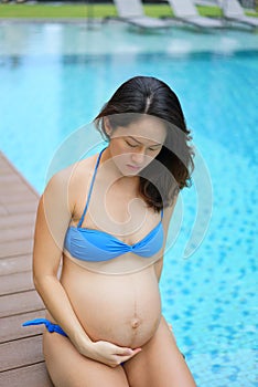 Asian Chinese Pregnant Woman Mother posing by the swimming pool photo