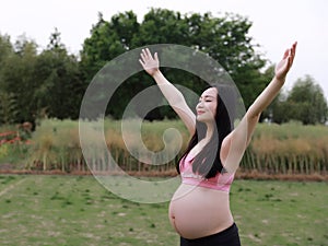 Asian Chinese pregnant woman in yoga dress embrace hug nature have fresh air enjoy peaceful life relax meditation in forest garden