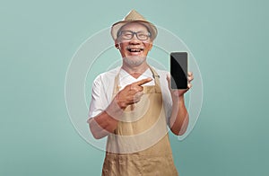 Asian Chinese Senior man in brown apron point finger on mobile phone