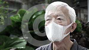 Asian Chinese senior man wearing mask protection from Coronavirus anxious and scare