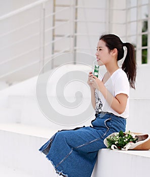 Asian Chinese university student drink milk on the playground