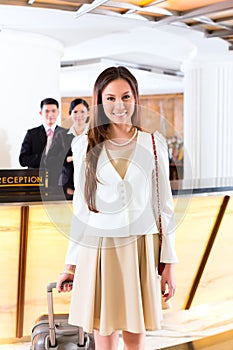 Asian Chinese woman arriving at hotel front desk