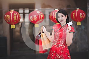 Asijský čínština žena v tradiční šaty držení nakupování taška a přes úvěr v čínština nový 