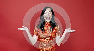 Asian chinese woman with red cheongsam or qipao exciting and laughing for wishing the good luck and prosperity in Chinese New Year