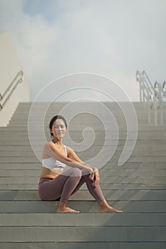 Asian Chinese Woman resting looking smart in sporting attire smiling happy