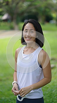 Asian chinese woman smiling sweetly outdoors garden active sporty holding mask