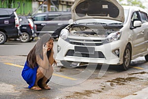 Asian Chinese woman in stress stranded on street suffering car engine failure having mechanic problem calling to insurance