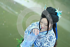 Asian Chinese woman in traditional Blue and white Hanfu dress, play in a famous garden