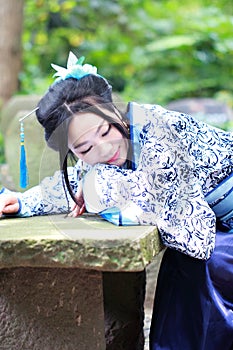 Asian Chinese woman in traditional Blue and white Hanfu dress, play in a famous garden