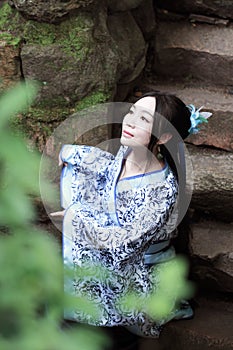 Asian Chinese woman in traditional Blue and white Hanfu dress, play in a famous garden