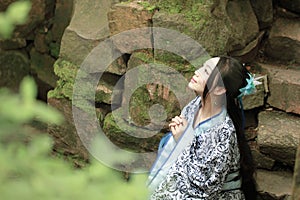 Asian Chinese woman in traditional Blue and white Hanfu dress, play in a famous garden