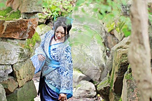 Asian Chinese woman in traditional Blue and white Hanfu dress, play in a famous garden