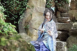 Asian Chinese woman in traditional Blue and white Hanfu dress, play in a famous garden