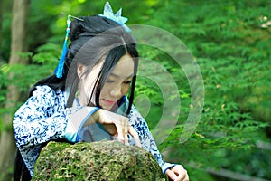 Asian Chinese woman in traditional Blue and white Hanfu dress, play in a famous garden