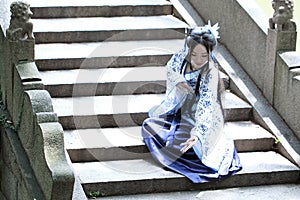 Asian Chinese woman in traditional Blue and white Hanfu dress, play in a famous garden