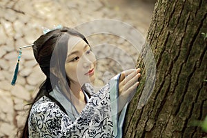 Asian Chinese woman in traditional Blue and white Hanfu dress, play in a famous garden