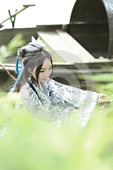 Asian Chinese woman in traditional Blue and white Hanfu dress, play in a famous garden