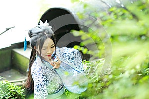 Asian Chinese woman in traditional Blue and white Hanfu dress, play in a famous garden