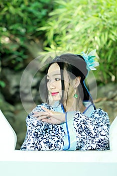 Asian Chinese woman in traditional Blue and white Hanfu dress, play in a famous garden ,Stand in front of the window