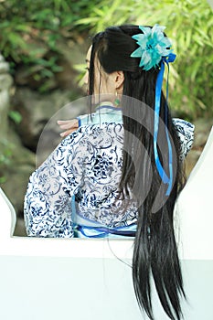 Asian Chinese woman in traditional Blue and white Hanfu dress, play in a famous garden ,Stand in front of the window