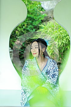 Asian Chinese woman in traditional Blue and white Hanfu dress, play in a famous garden ,Stand in front of the window