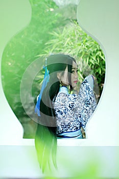 Asian Chinese woman in traditional Blue and white Hanfu dress, play in a famous garden ,Stand in front of the window