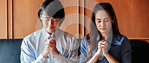 Asian Christian woman and man holding hands in praying for Jesus` blessings to show love and confession of their sins according t